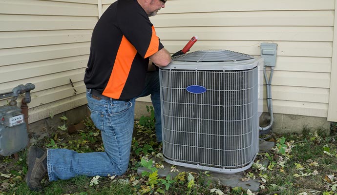 A person is replacing an outdoor AC unit