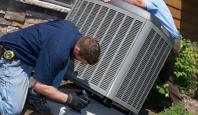 A person is installing outdoor AC units.