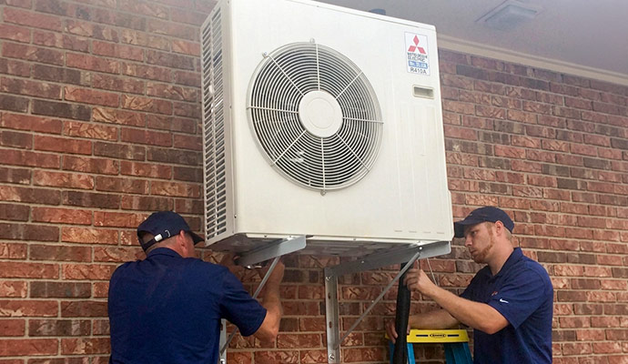 Technicians installing an outdoor HVAC unit