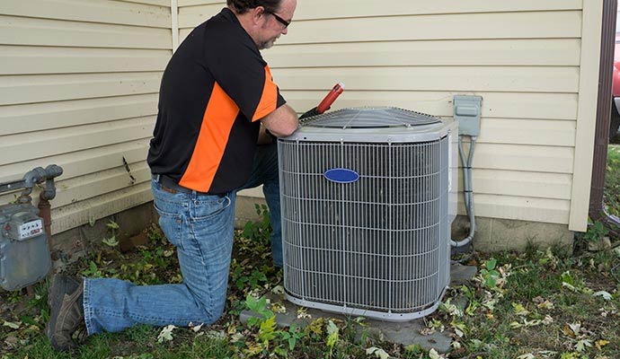 Technician inspecting an outdoor residential ac unit
