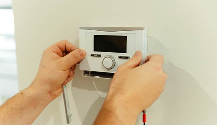 Technician installing a digital thermostat