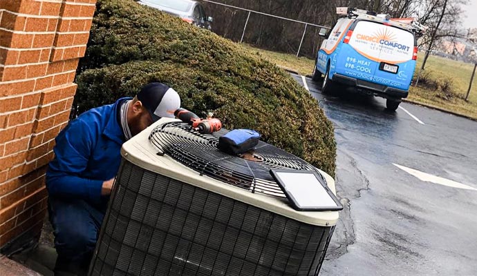 Technician performing emergency AC repair on an outdoor unit