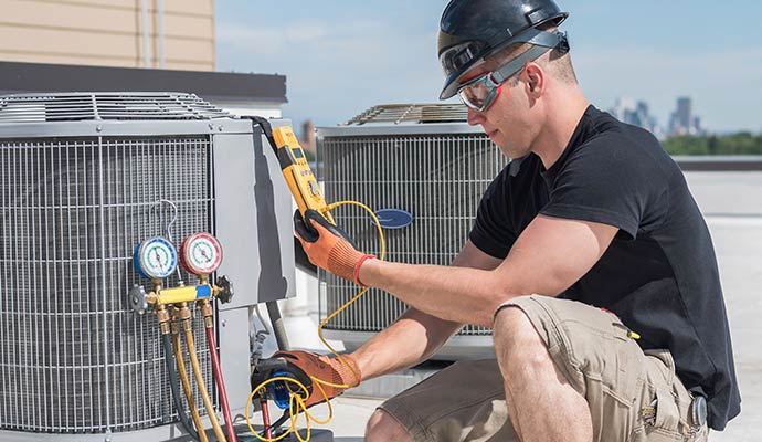 Technician servicing an outdoor commercial ac unit