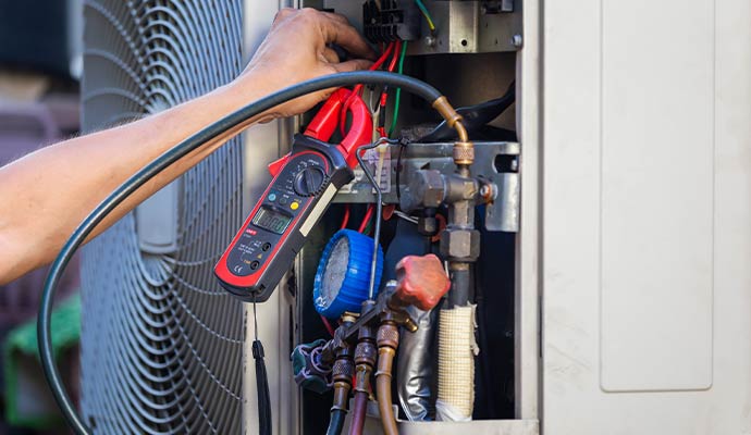 Technician test the electrical wiring of an AC unit