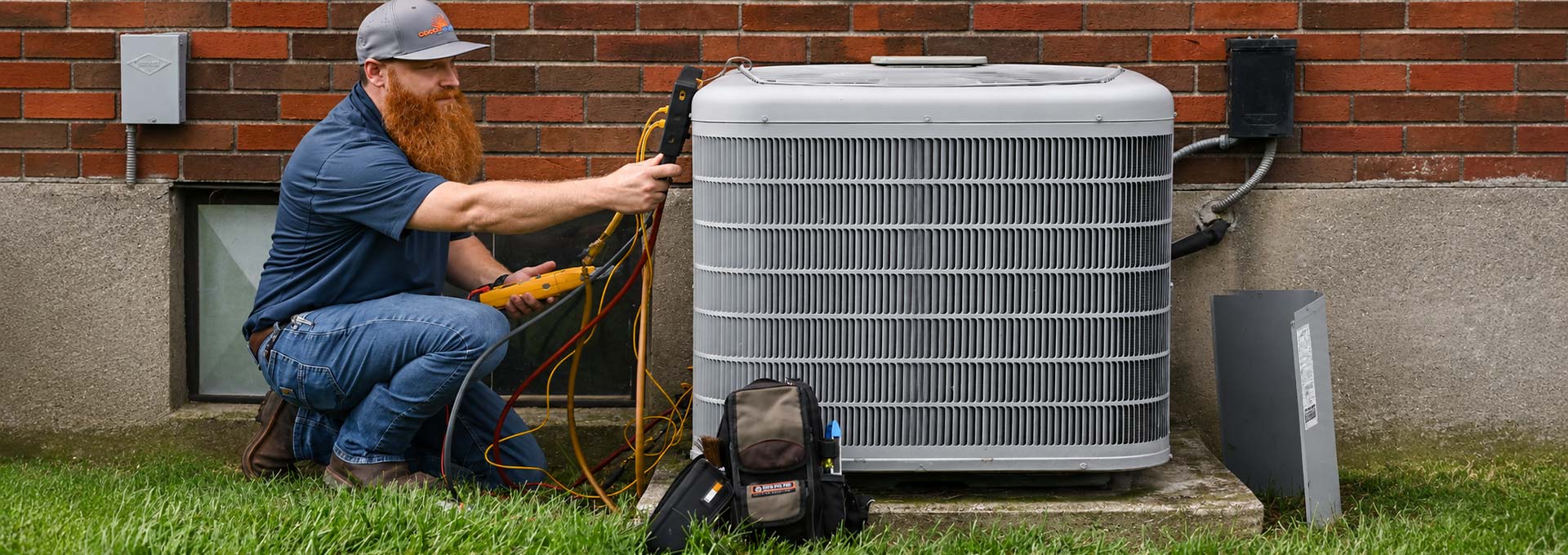 Technician servicing an outdoor air conditioning unit