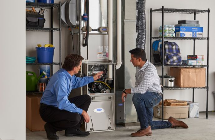hvac technician explaining to homeowner at the furnace