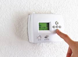 Digital programmable thermostat on wall