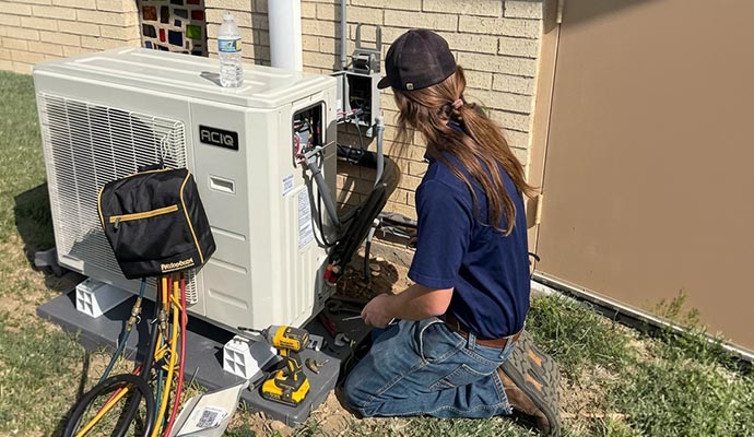 Expert servicing outdoor air conditioning unit