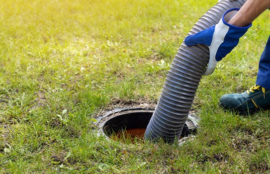 Professional worker cleaning septic tank