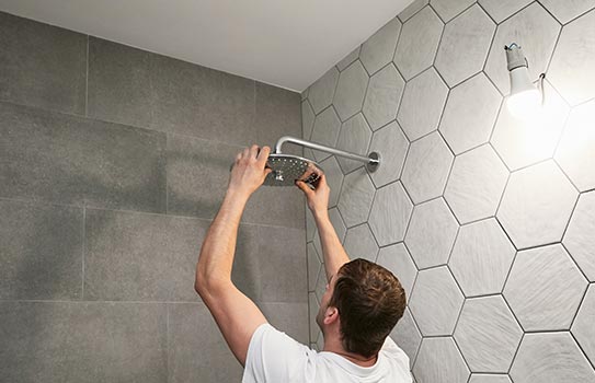 A person replacing showerhead