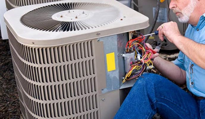 Professional worker repairing heat pump