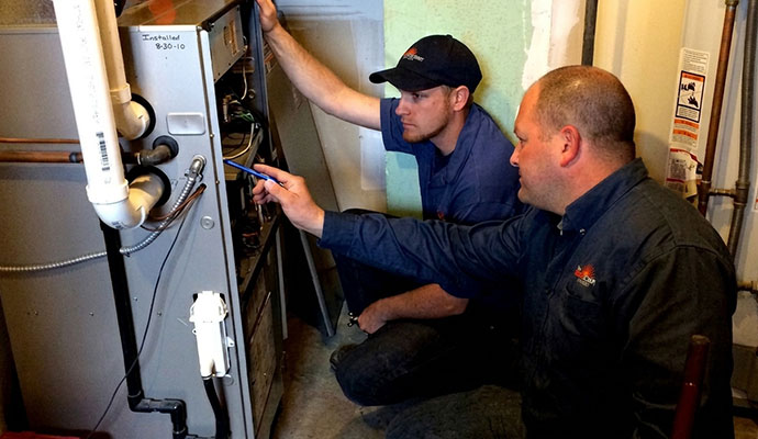 Two experts repairing furnace
