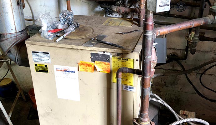 An old weil-mclain oil boiler heating system basement.