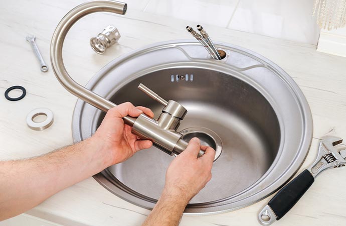 Professional worker installing sink and faucet