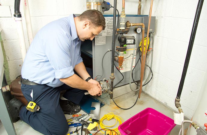 plumber repairs furnace