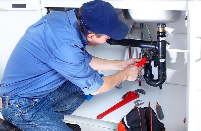 Professional worker fixing bathroom plumbing
