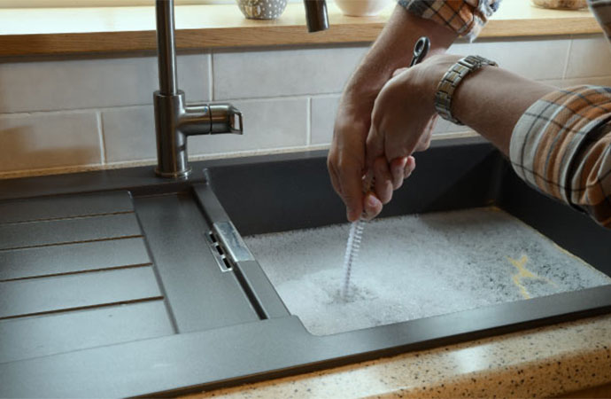 Expert plumber fixing clogged sink