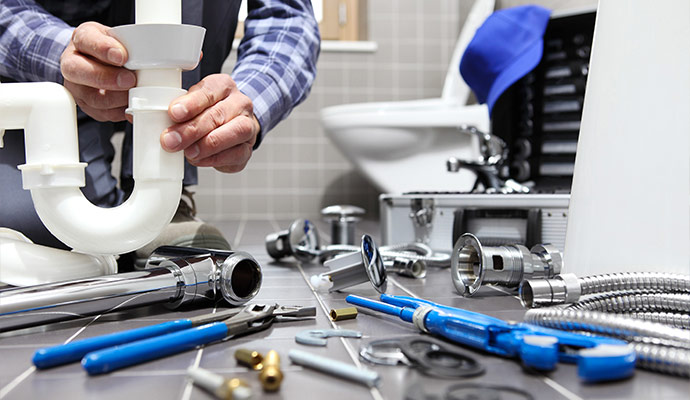 Plumber repairing bathroom pipe trap
