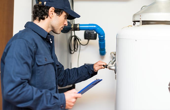 A professional performing maintenance on a water heater