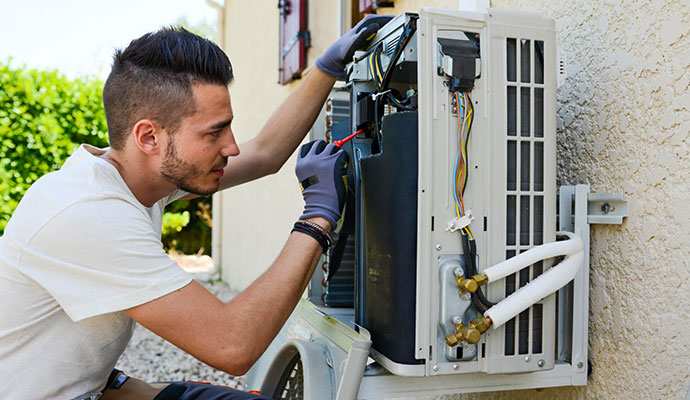 Technician maintaining outdoor AC unit