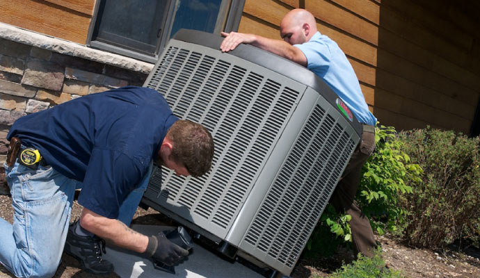 two professionals installing an air conditioner