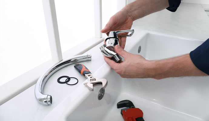 plumber fixing kitchen water tap
