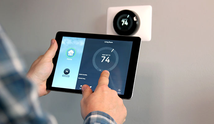 User adjusting smart thermostat with digital tablet